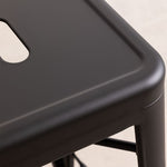 Tabouret en métal noir mat à assise rectangulaire avec encoche et bords arrondis