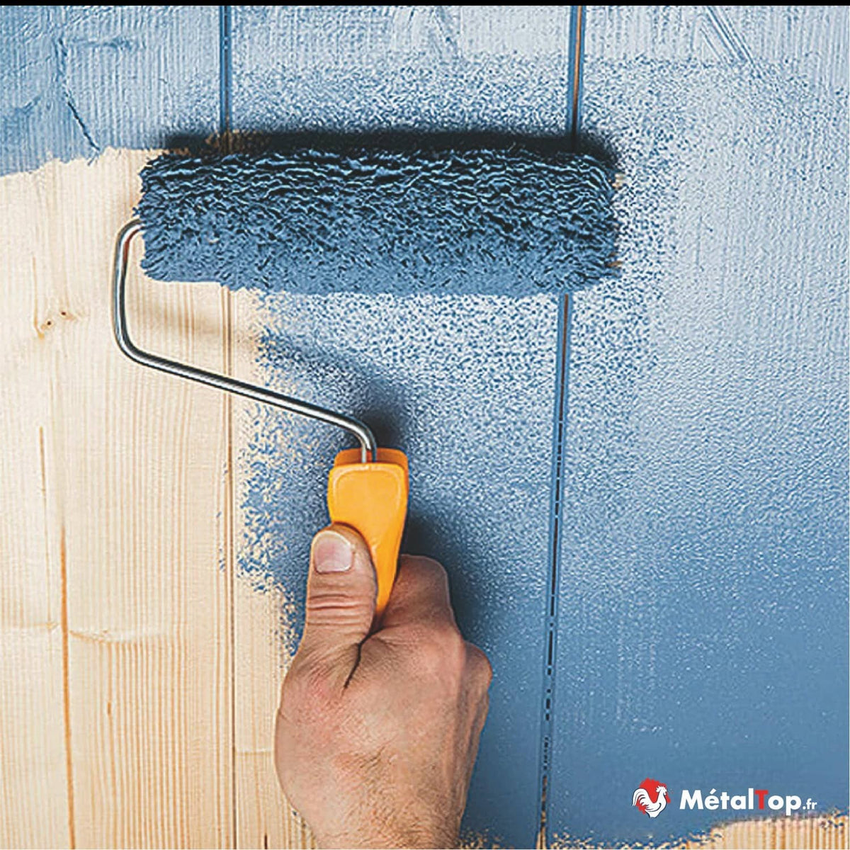 Application de peinture bleue au rouleau sur des planches de bois clair
