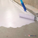 Application de peinture blanche au rouleau sur un sol en béton gris