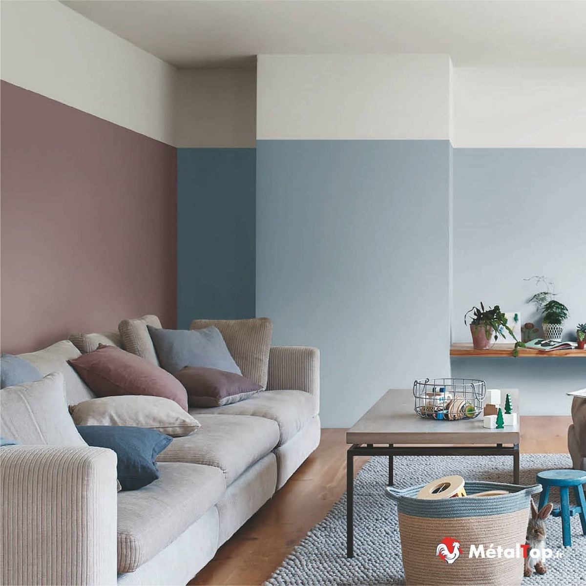 Salon aux murs peints en blocs rose poudré, bleu et crème, avec canapé beige en velours côtelé