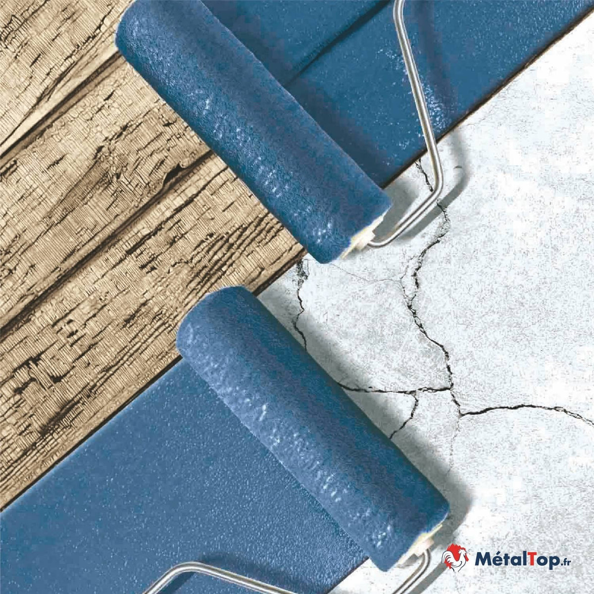 Rouleaux à peinture bleue sur un sol en béton fissuré, à côté d'un parquet en bois