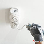 Rouleau à peinture blanc appliquant de la peinture sur un mur blanc, avec gant de protection