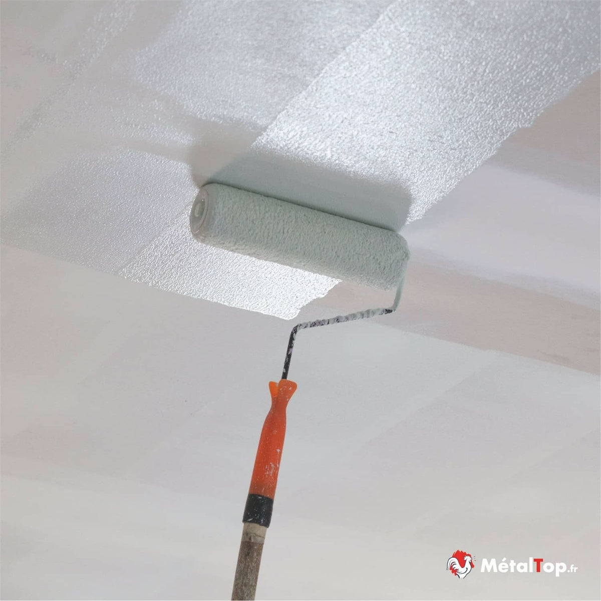 Application de peinture blanche au rouleau sur un plafond texturé