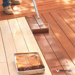 Application d'un produit de finition au rouleau sur une terrasse en bois