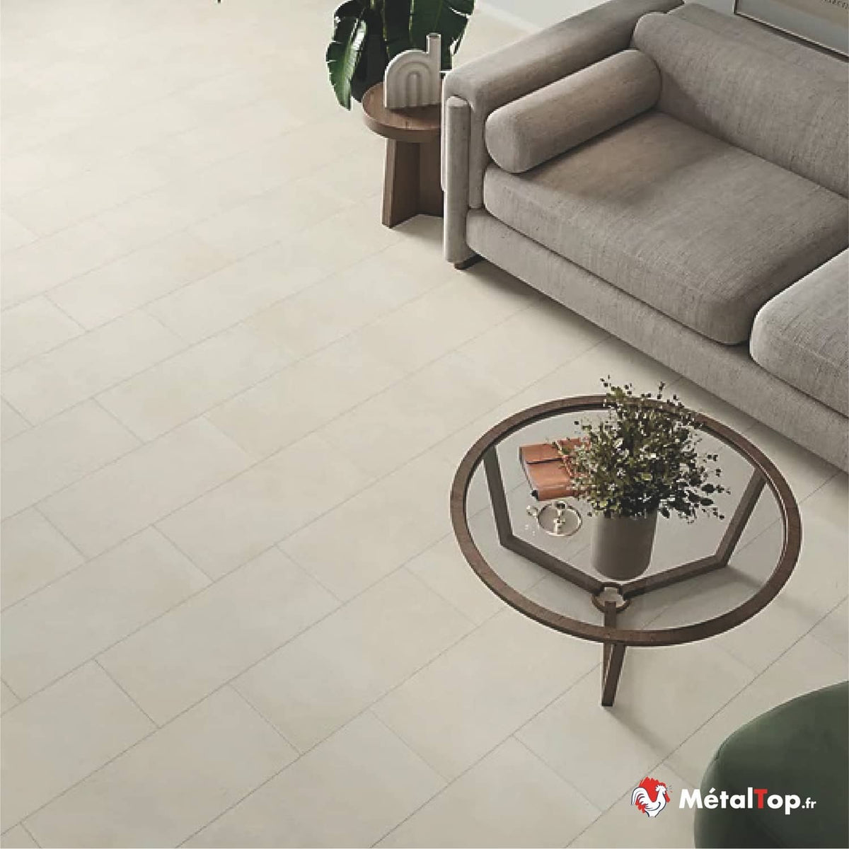 Canapé gris en tissu et table basse ronde en bois sur sol carrelé beige clair