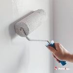 Rouleau à peinture appliquant une peinture blanche sur un mur blanc
