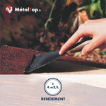 Application d'enduit bitumineux rouge à la spatule sur une plaque de toiture, rendement ±4 m²/L