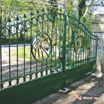 Portail en fer forgé vert avec cercles, pointes et médaillons dorés ornés de volutes