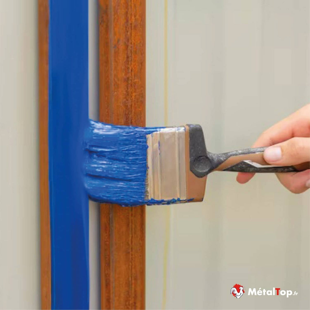 Peinture bleue appliquée au pinceau sur un profilé métallique rouillé