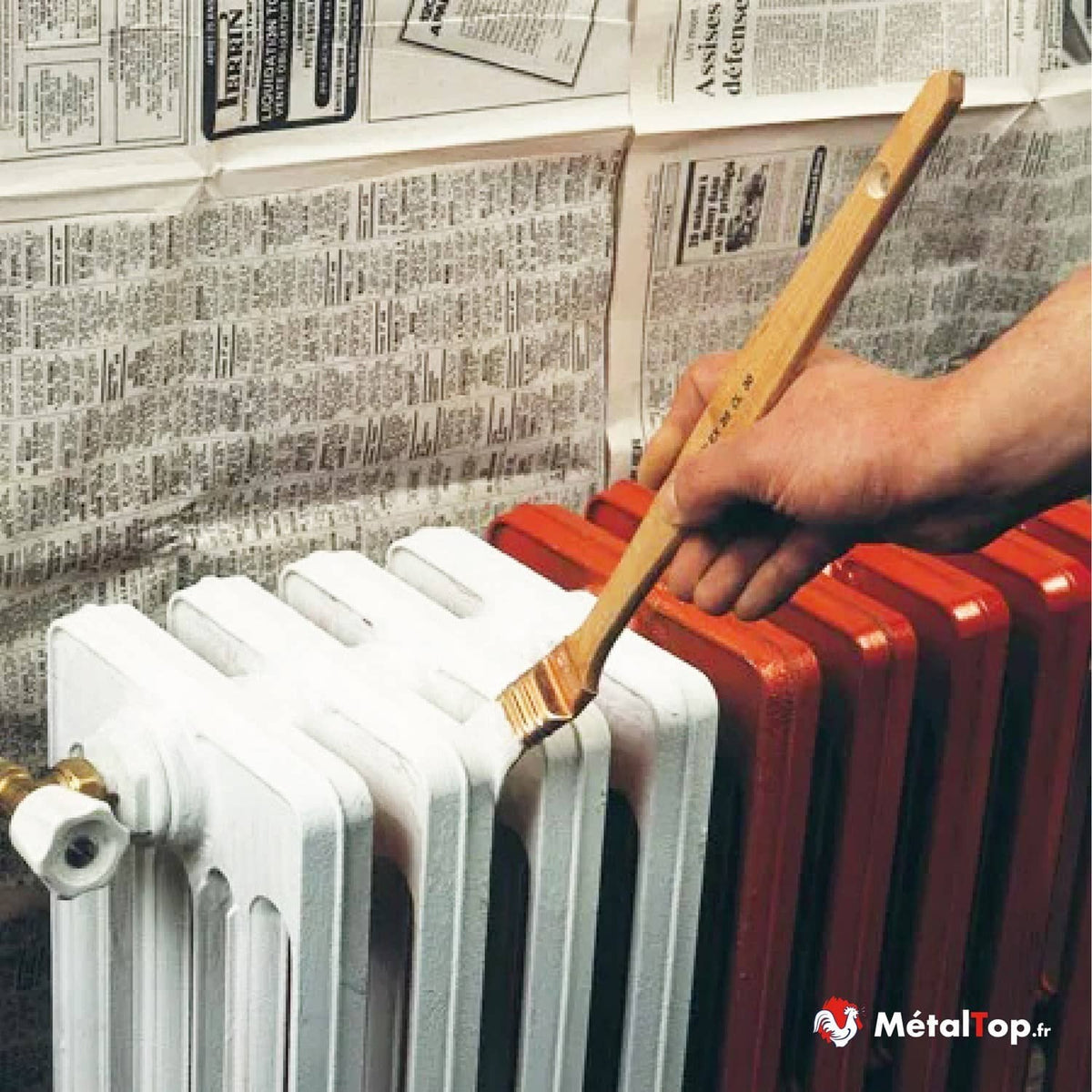 Peinture au pinceau d'un radiateur en fonte blanc, à côté d'un radiateur déjà peint en rouge