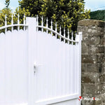 Portail blanc à lames verticales et pointes décoratives, fixé à un pilier en pierre