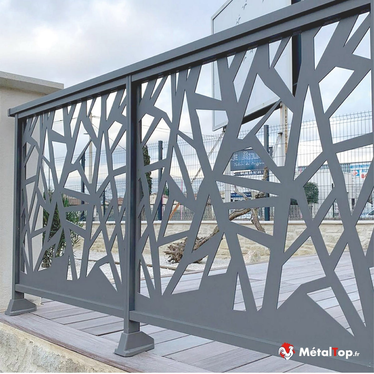Garde-corps métallique gris à motifs géométriques découpés sur terrasse en bois