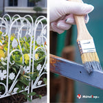 Clôture de jardin en métal blanc ornée de fleurs; pinceau peignant une barre métallique bleue