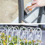 Peinture au pinceau d'une clôture métallique grise et bordure de jardin blanche en fer forgé