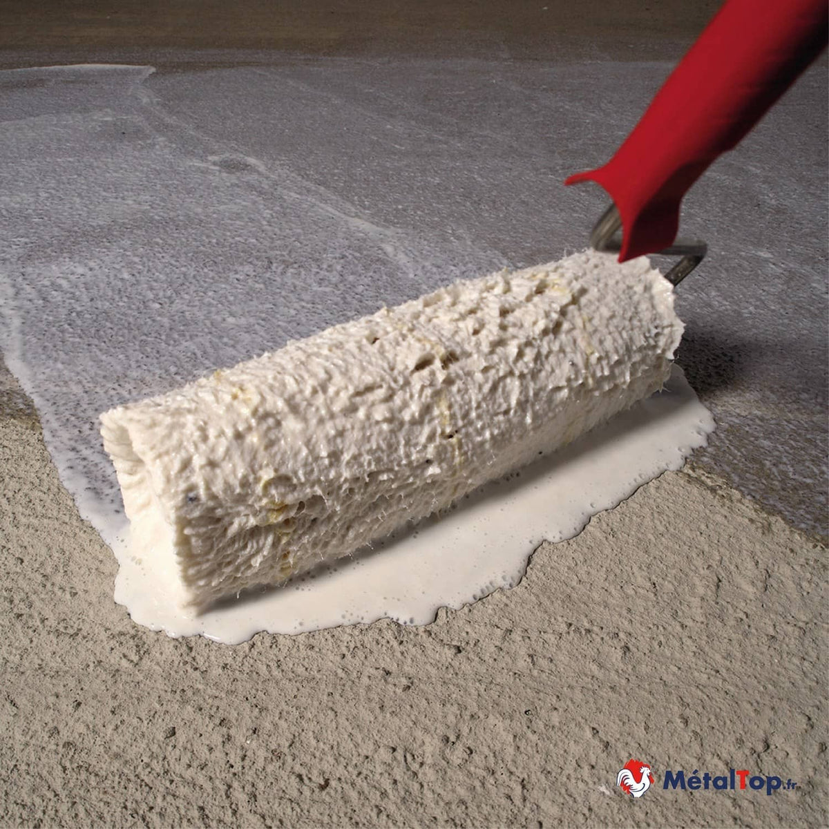 Application d'un produit blanc au rouleau texturé sur une surface en béton gris