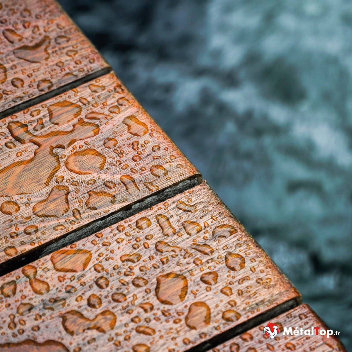 Planches de bois couvertes de gouttes d'eau, avec une mer agitée en arrière-plan