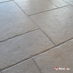 Sol en carrelage beige effet pierre, posé en grands rectangles à joints clairs