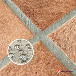 Joints gris entre carreaux terre cuite, avec gouttes d'eau perlant en surface, illustrant l'effet hydrofuge