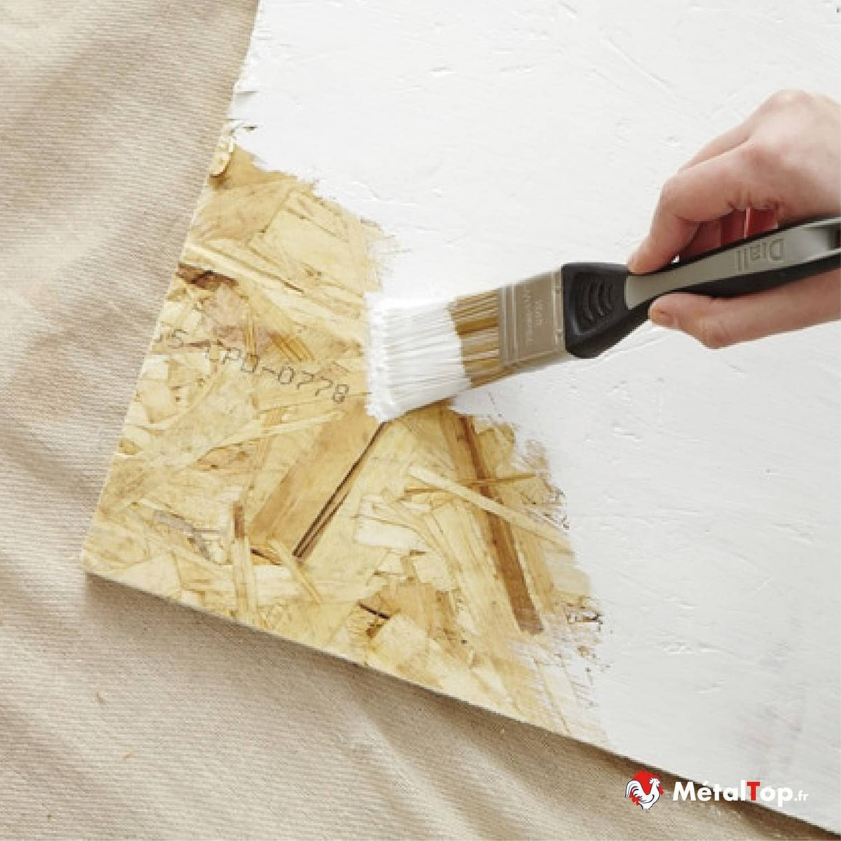 Application de peinture blanche au pinceau sur un panneau OSB en bois
