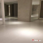 Sol en résine blanc mat dans un hall moderne avec colonnes blanches et cloisons en miroir