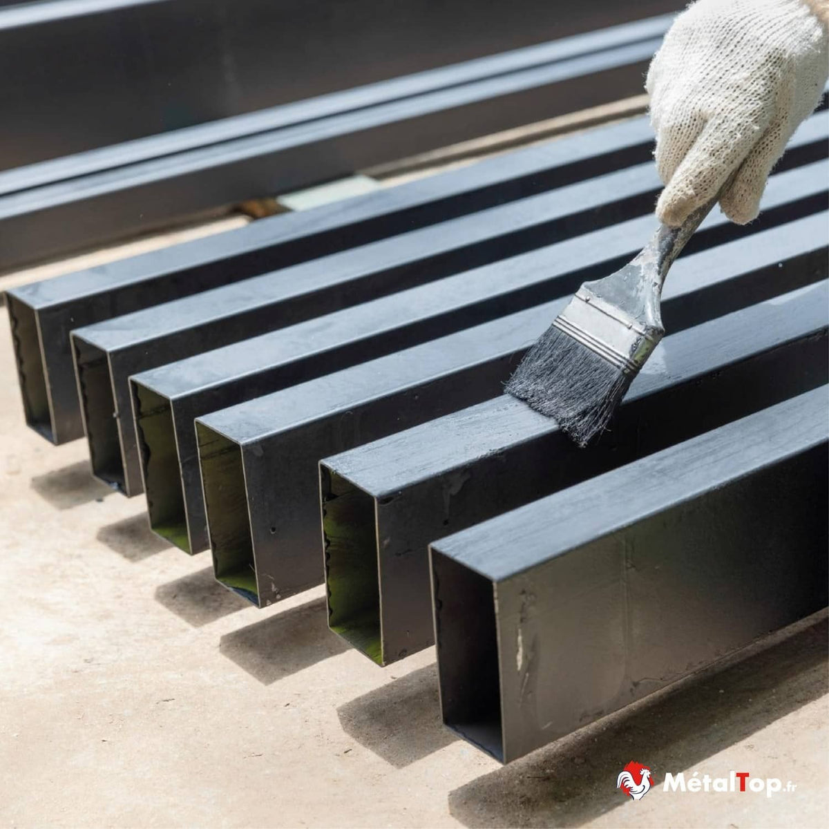 Profilés carrés en acier noir en cours de peinture au pinceau