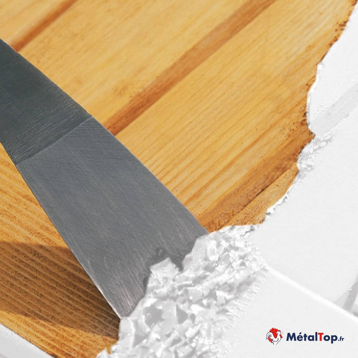Application d'enduit blanc au couteau à enduire sur une surface en bois clair