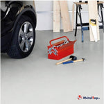 Garage avec voiture noire, boîte à outils rouge, maillet, marteau et planches de bois