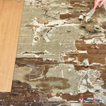Parquet ancien dégradé, revêtement décollé en cours de grattage à la spatule