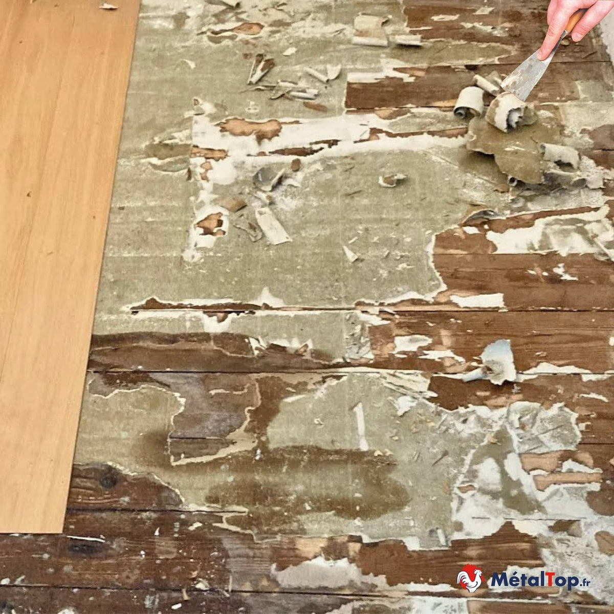 Parquet ancien dégradé, revêtement décollé en cours de grattage à la spatule