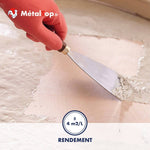 Application d'un enduit blanc à la spatule sur un sol beige, rendement de 4 m²/L