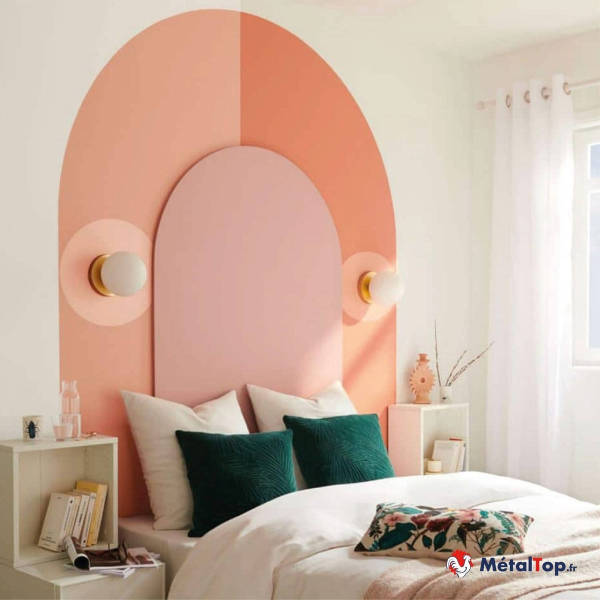 Tête de lit arquée rose et corail, deux appliques dorées, coussins verts et blancs sur un lit