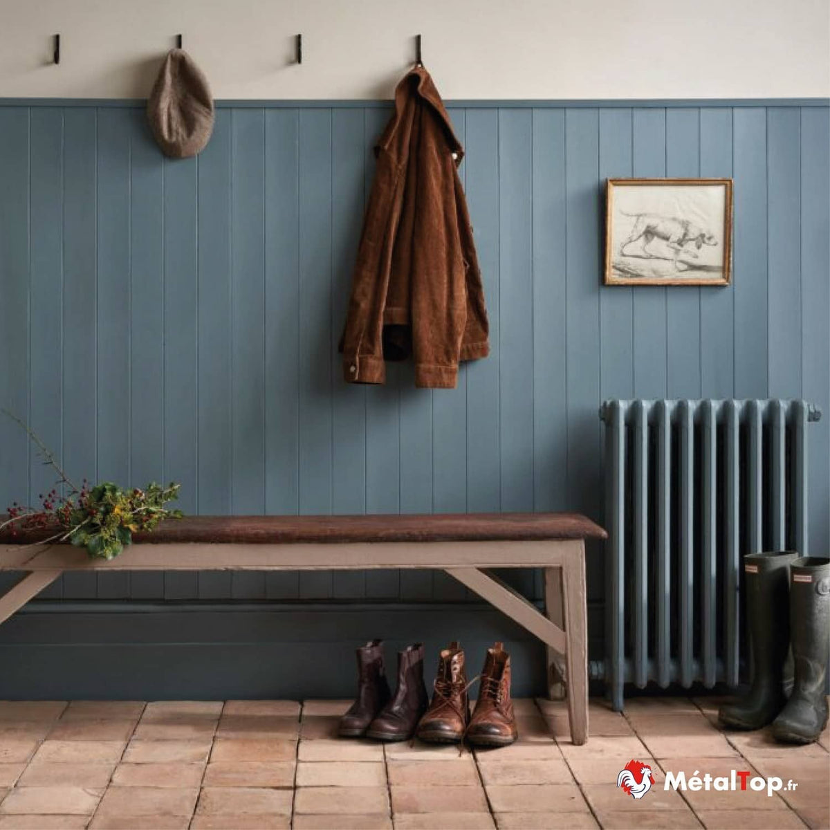 Entrée aux lambris bleu gris, radiateur à colonnes, veste en velours brun et banc en bois