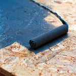Application d'une peinture bleu foncé au rouleau sur un panneau OSB