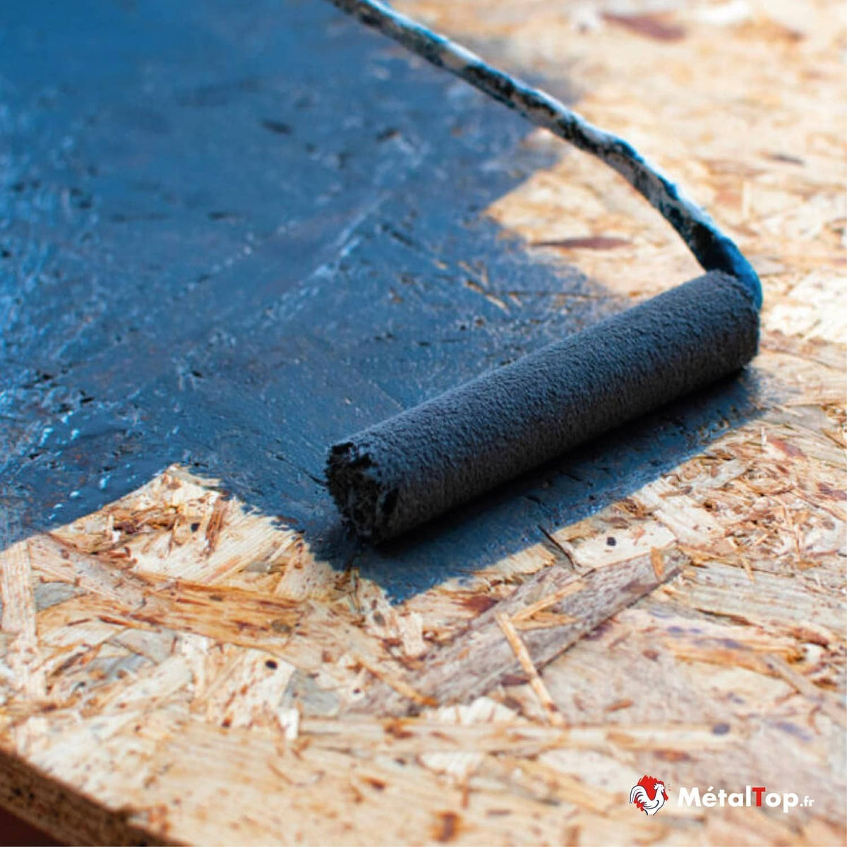 Application d'une peinture bleu foncé au rouleau sur un panneau OSB