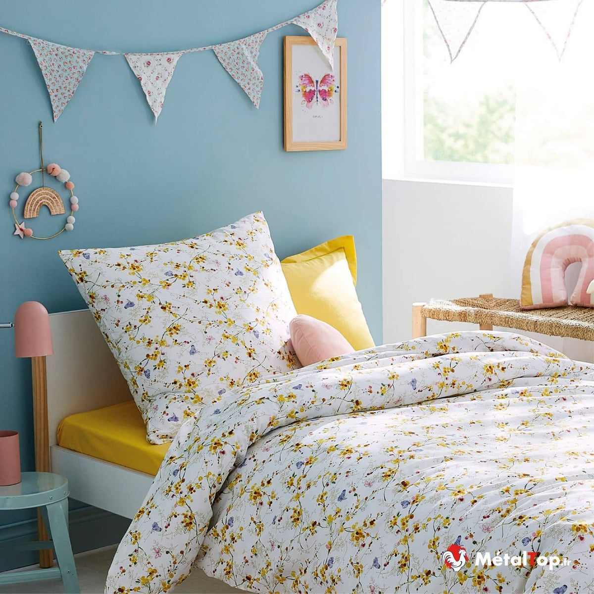 Parure de lit blanche à fleurs jaunes et papillons dans une chambre d'enfant aux murs bleus