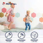 Enfants jouant sur un lit blanc, mur peint d'hexagones colorés – peinture MétalTop