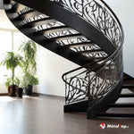 Escalier courbe noir à garde-corps en fer forgé aux motifs floraux, marches en bois foncé