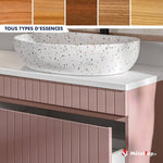 Vasque ovale blanche mouchetée sur meuble rose à façades cannelées, essences de bois