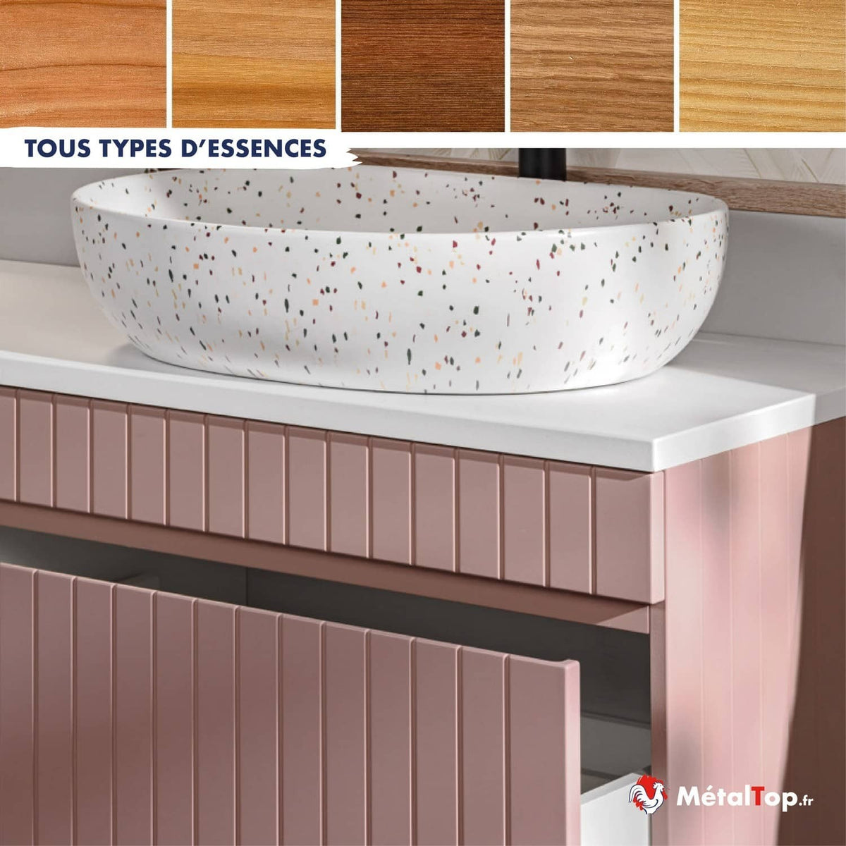 Vasque ovale blanche mouchetée sur meuble rose à façades cannelées, essences de bois